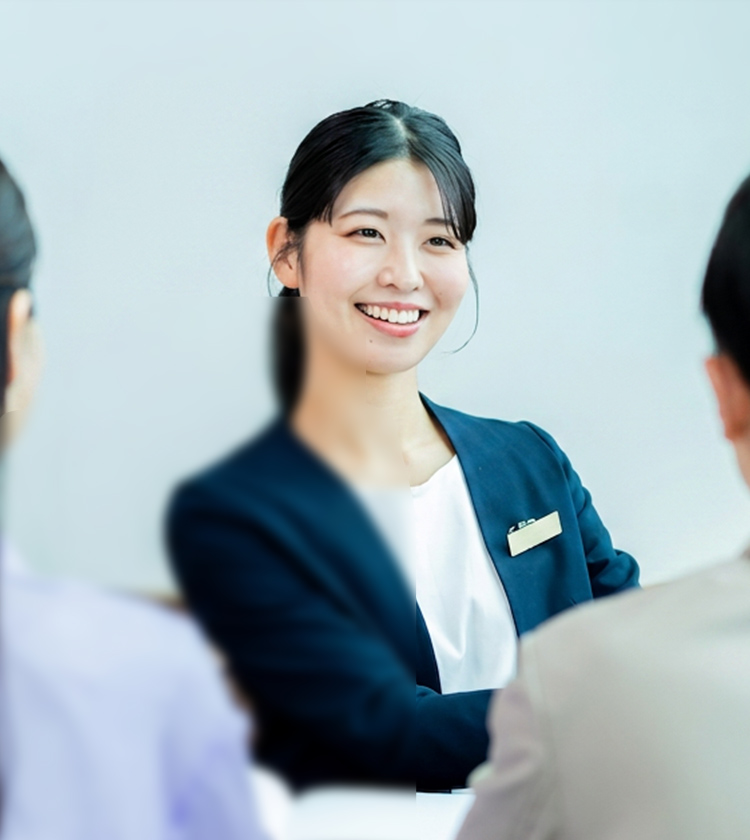 来訪者と向き合い笑顔で応対する女性スタッフ